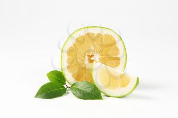 green grapefruit half and slice on white background