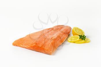 Fresh salmon fillet and lemon on white background