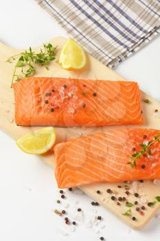 raw salmon fillets with salt, peppercorns, thyme and lemon