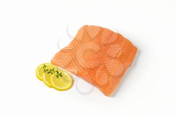 Fresh salmon fillet and lemon on white background