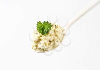 Crumbly white cheese spread on spoon