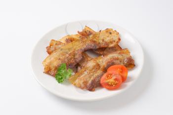 Pan fried side pork bacon slices on plate