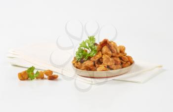 plate of salty pork scratchings on white napkin