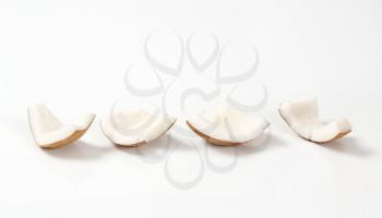 pieces of peeled coconut on white background