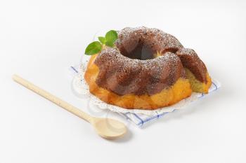 marble bundt cake on checkered dish towel and wooden spoon