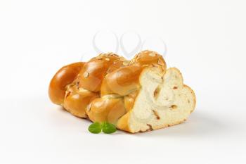 half a loaf of sweet braided bread on white background