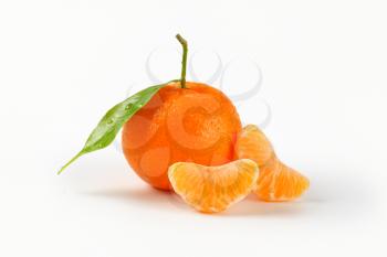 freshly washed tangerine with segments on white background