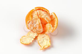 peeled ripe tangerine on white background