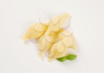 pile of cooked pasta shells on white background