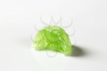 bitten green jelly candy on white background