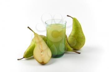 glass of pear juice and fresh pears next to it