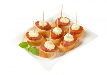 Bread based canapes with spicy sausage and creamy spread