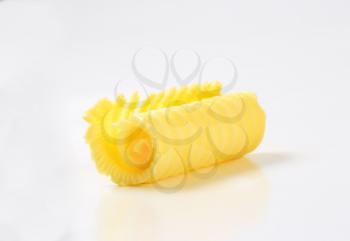 Curl of fresh butter on white background