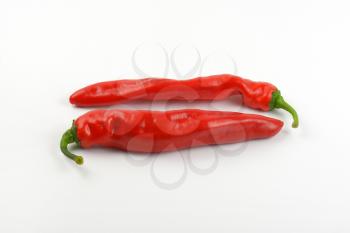 two red peppers on white background