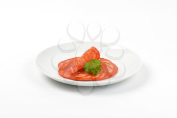 plate of chorizo salami slices on white background
