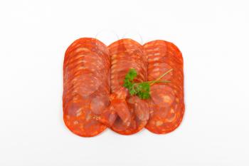 slices of chorizo salami on white background