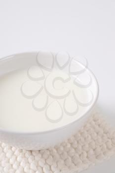 bowl of fresh milk on white table mat