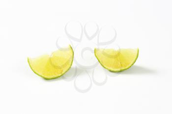 two slices of fresh lime on white background