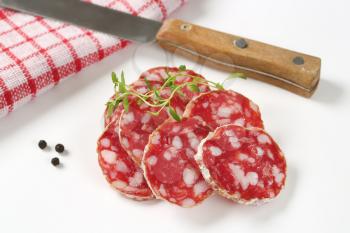 thin slices of dry cured sausage and knife