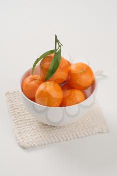bowl of fresh tangerines on white table mat