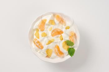 bowl of sour cream with fresh tangerine and corn flakes
