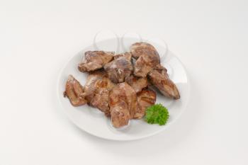 plate of pan fried chicken liver on white background