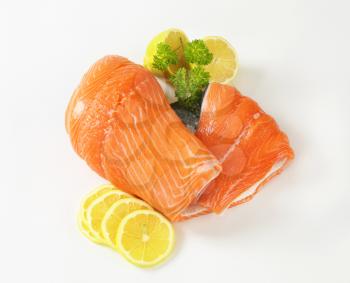 raw salmon fillet and lemon slices on white background