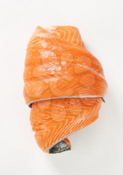 roll of raw salmon fillet on white background