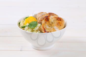 roasted chicken breast with rice and oranges in white bowl