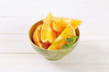 slices of fresh orange in green bowl