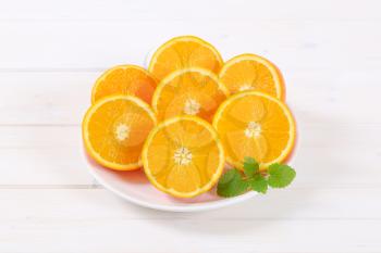 plate of halved oranges on white background