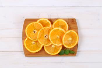 thin slices of fresh orange on wooden cutting board