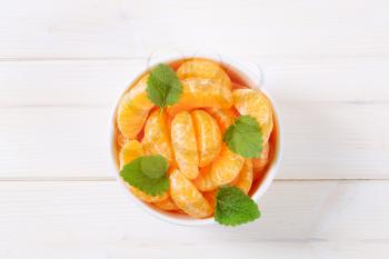 bowl of fresh tangerine slices on white background