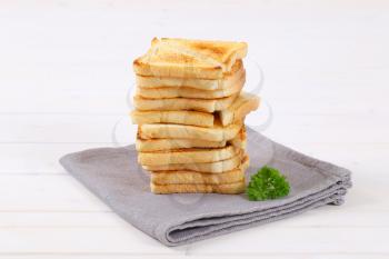 stack of toasted bread slices on grey place mat