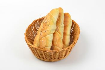 white rolls topped with salt and caraway seeds in bread basket