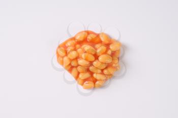 handful of beans in tomato on white background