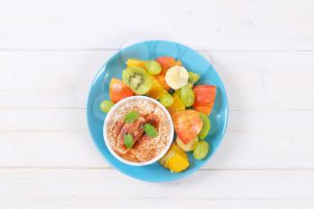 fresh fruit salad with cinnamon yogurt on turquoise plate