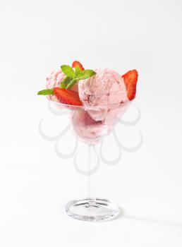 scoops of strawberry ice cream and fresh strawberries in cocktail glass