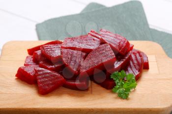 sliced and pickled beetroot on wooden cutting board - close up