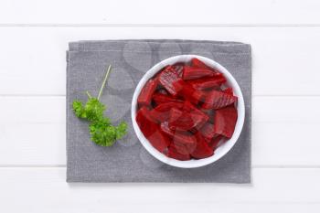 bowl of sliced and pickled beetroot on grey place mat