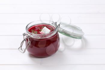 jar of beetroot cream soup on white wooden background