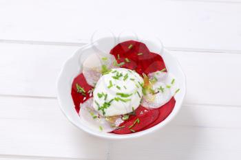 bowl of thin beetroot and white radish slices with yogurt