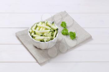 bowl of zucchini strips on beige place mat