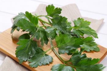 fresh parsley leaves on wooden cutting board - close up