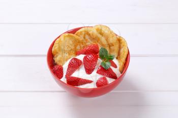 bowl of american pancakes with white yogurt and fresh strawberries on white wooden background