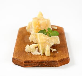 Pieces of Parmesan cheese on wooden cutting board