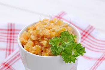 Cooked red lentils in white porcelain cup