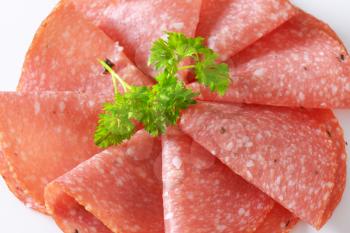 detail of thin slices of spicy salami with parsley