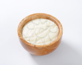wooden bowl of semolina pudding on white background