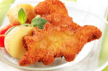 Fried dinosaur-shaped fish nuggets with new potatoes